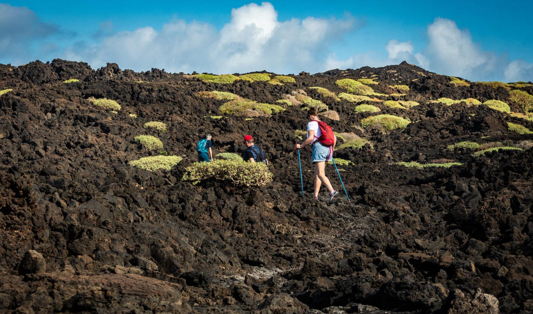 Hikers traversing volcanic terrain in the Canary Islands